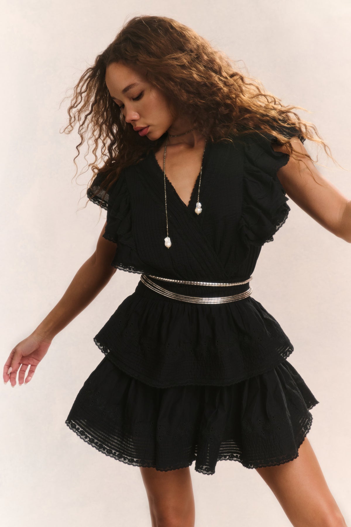 Black V-neck mini dress with short ruffle sleeves and tiered skirt layers, elastic waist