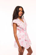 Pink floral print mini dress with V-neck wrap look, flutter ruffle sleeves and tiers.