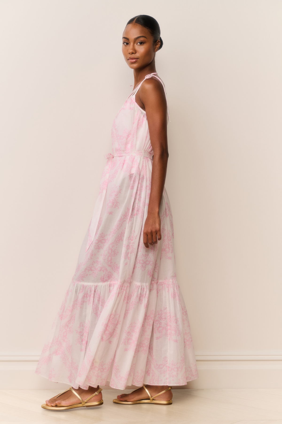 Side view of toile print cover-up dress with thin straps, tie waist, and layered hem