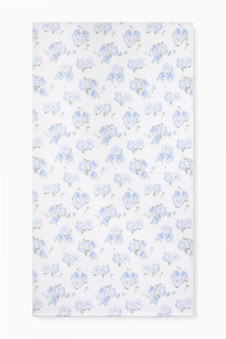 Hali beach towel in blue with all-over floral print, laid flat