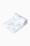 Hali beach towel in blue with all-over floral print, rolled up