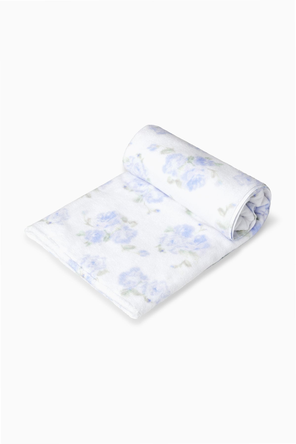 Hali beach towel in blue with all-over floral print, rolled up