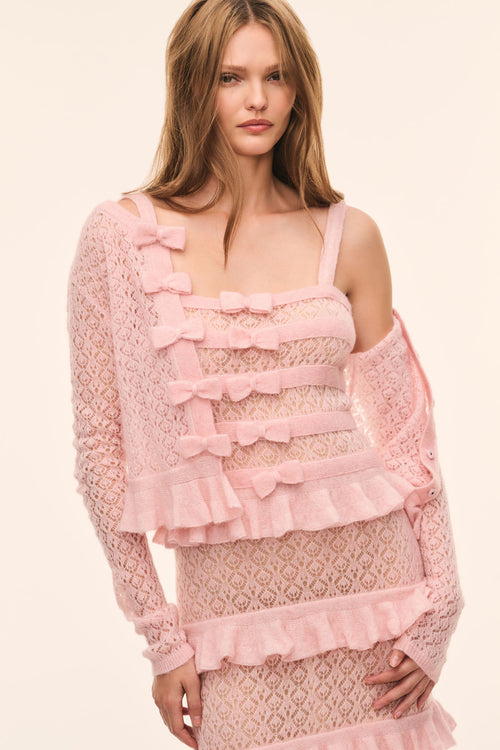 Light pink pointelle cardigan with layered ruffle front and bow trim, long sleeves