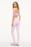 Light mauve bow-print sports bra with thin straps, full-body worn view