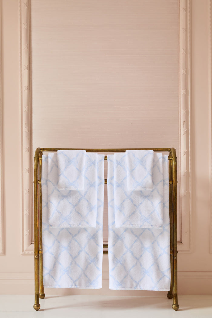Folded white bath towels with light blue diamond lattice print
