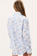 Unisex shirt back view in light blue floral print with long sleeves and collar