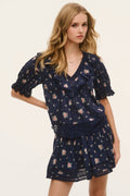 Navy floral cotton blouse with V-neck, fluttery ruffle sleeves, and elastic waist detail.