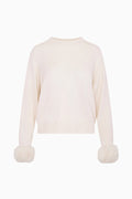 Ivory wool-cashmere sweater flat lay with faux fur pom cuffs
