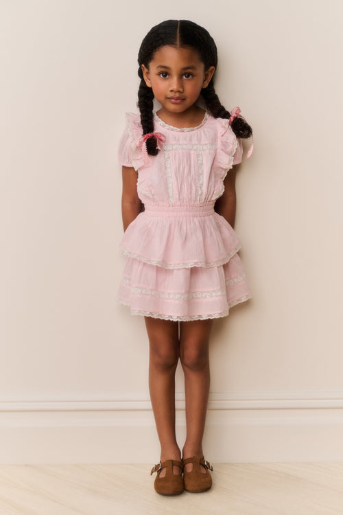 Pink lace-trimmed cotton dress with ruffled bodice, tiered skirt, and bow sleeves
