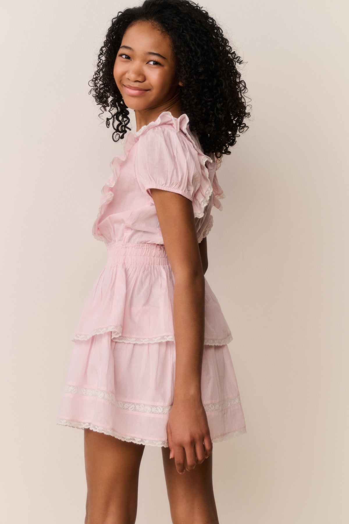 Pink cotton mini dress with short puff sleeves and layered ruffle skirt