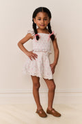 Girls floral cotton mini skirt standing view; light ivory with gathered waist and ruffles