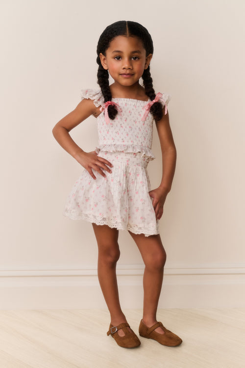 Girls floral cotton mini skirt standing view; light ivory with gathered waist and ruffles