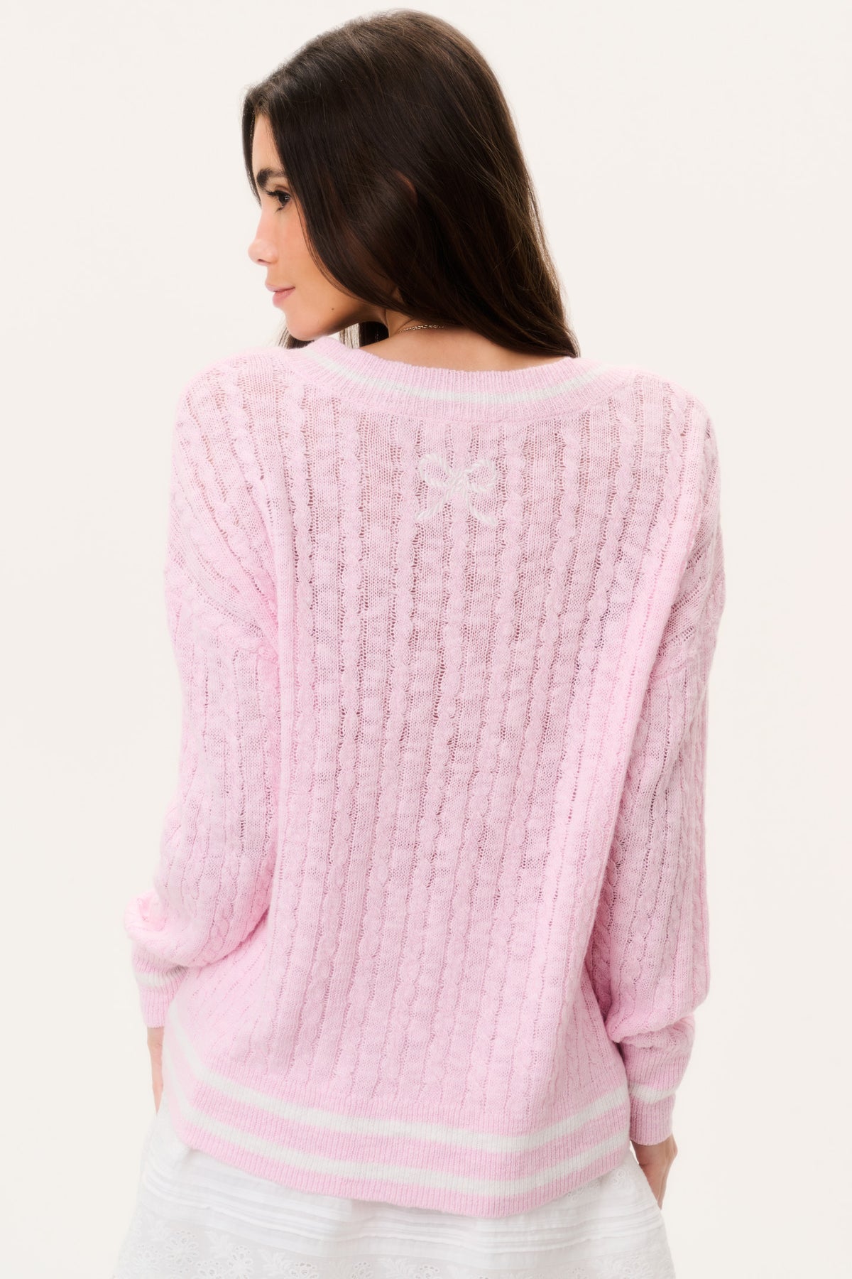 Pink back view of cable knit pullover sweater with V-neck ribbed striped hem