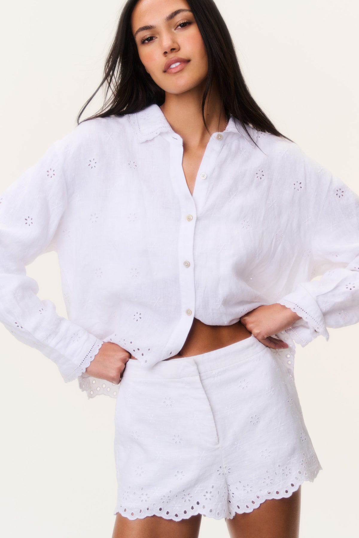 White linen eyelet shorts with scalloped hem and embroidered eyelet pattern