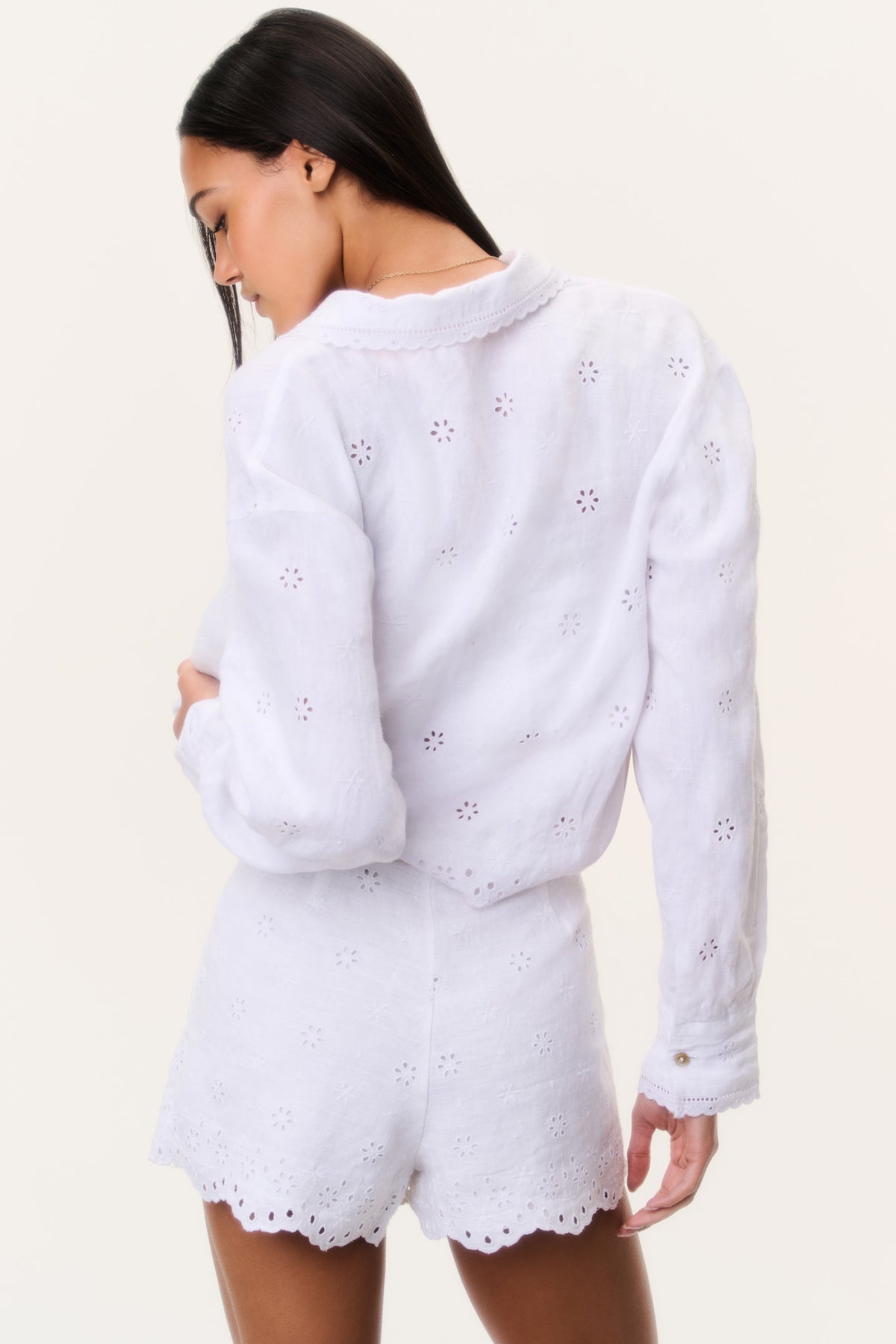 White linen eyelet shorts, back view with scalloped hem and embroidered eyelets