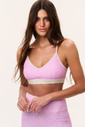 Ditsy floral sports bra on pale fabric with pink trim; front view on model