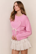 Pink wool-cashmere pullover with large heart applique and ribbon tie