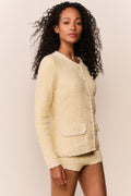 Light yellow knit tweed mini shorts, side view, scalloped lace-trim hem