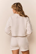 White fleece shorts, back view with eyelet embroidery and elastic waistband