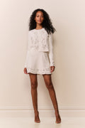 White knit mini skirt featuring eyelet bandana pattern and scalloped hem
