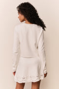 White eyelet knit cardigan back view with long sleeves and scalloped lace hem.