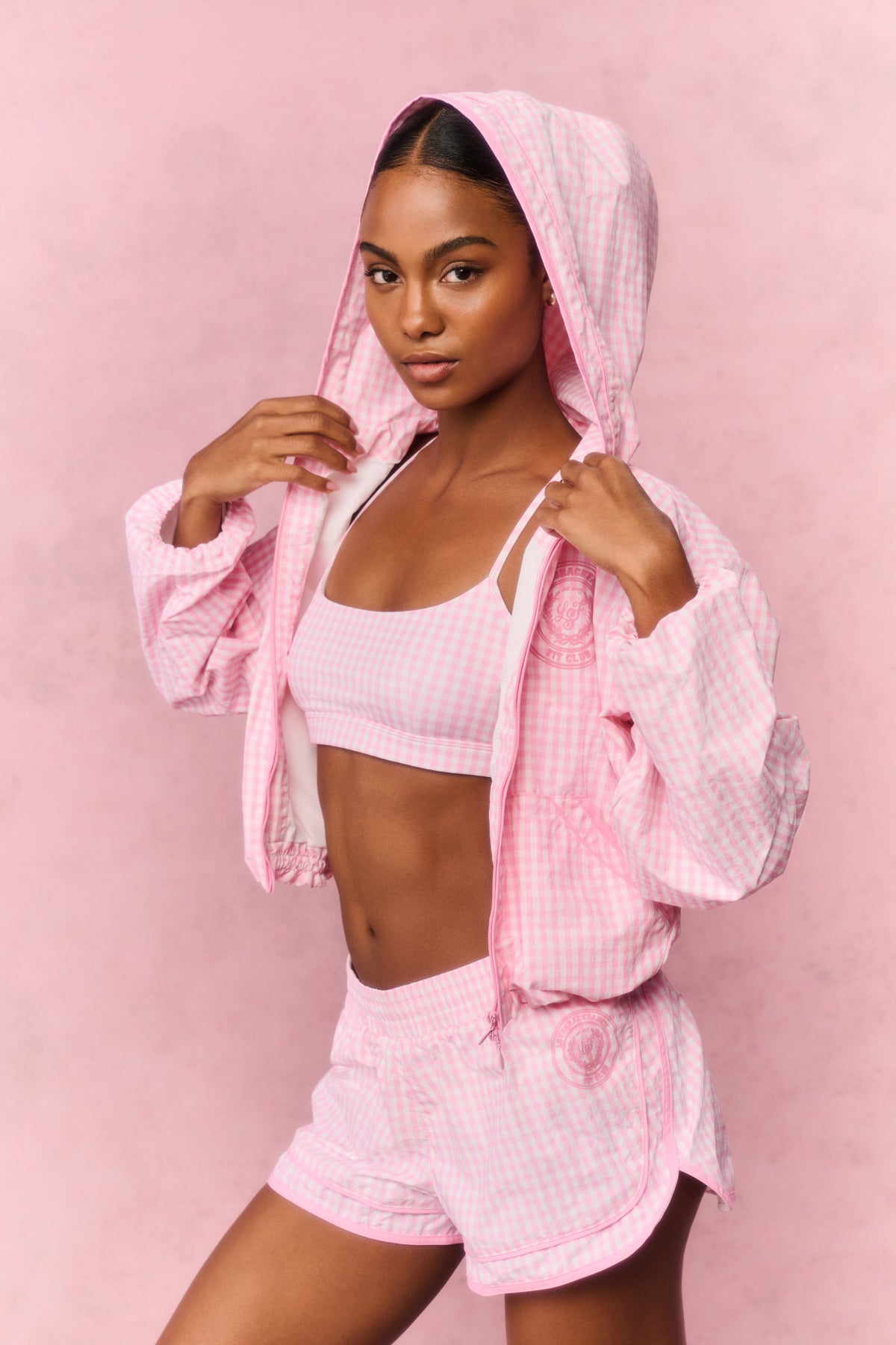 Pink gingham windbreaker with hood up and full zip front, cropped and gathered hem.