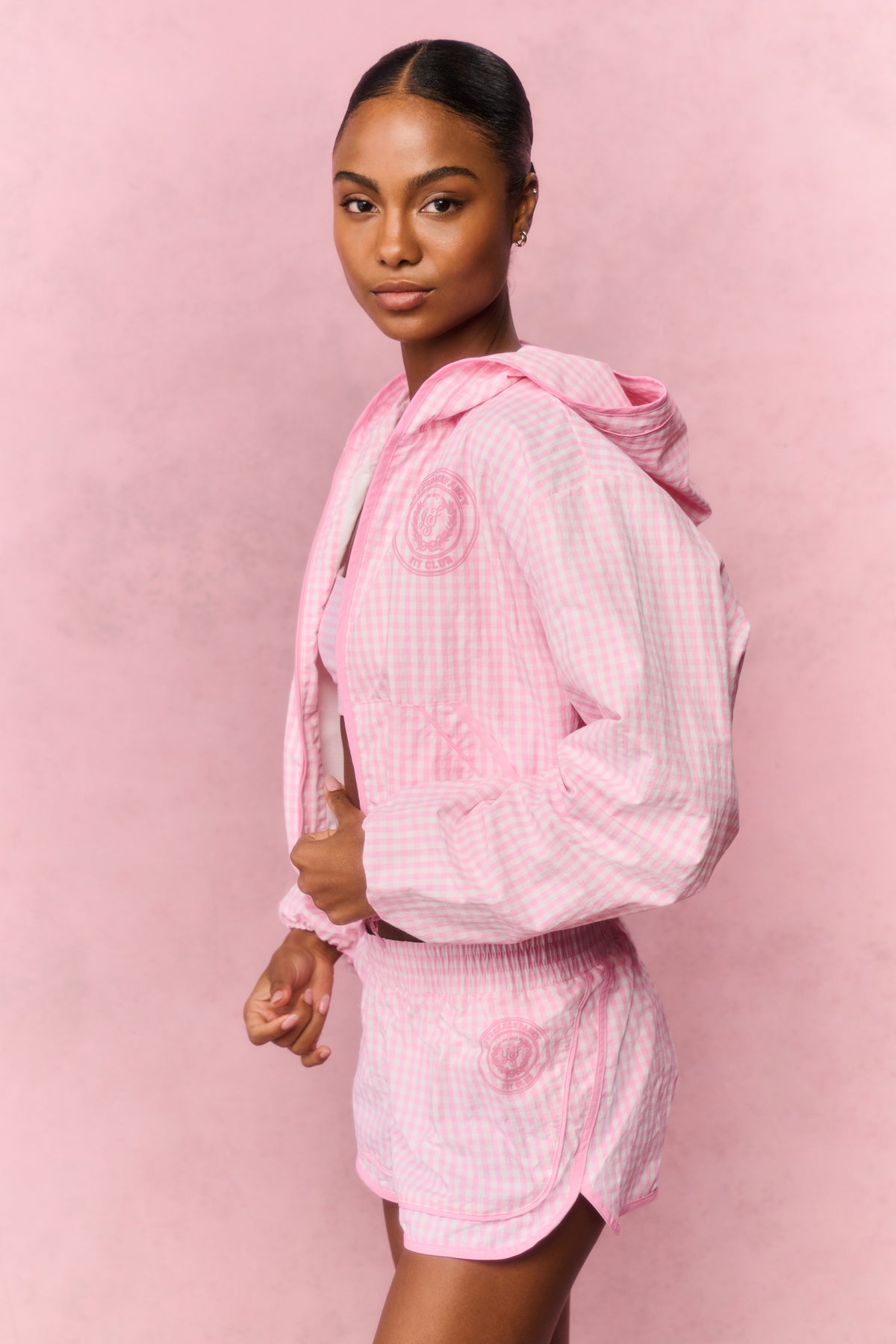 Pink gingham windbreaker shorts with elastic waistband and ruffled hem, side view