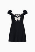 Tween Karola black mini dress with white lace bow and short puff sleeves