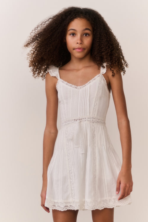 White cotton mini dress with ruffle straps, smocked bodice, layered lace hem