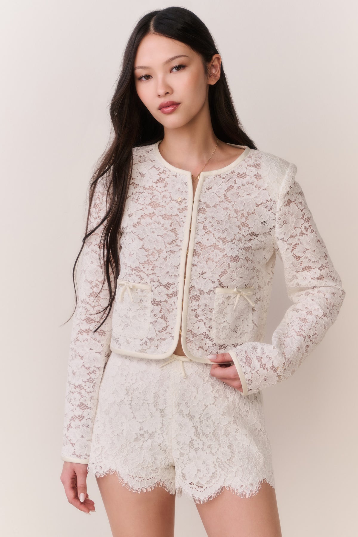 Ivory lace mini shorts with scalloped trim and floral lace pattern, front view