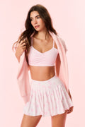 Pink patterned sports bra with thin straps and V neckline, ruched bust