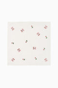 White embroidered napkin with scattered pink and red bow motifs