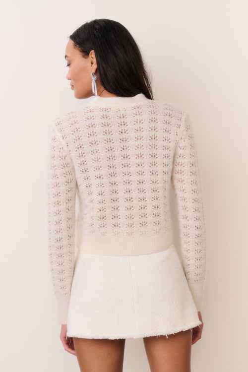 Back view of light cream knit bow cardigan with patterned texture and button front