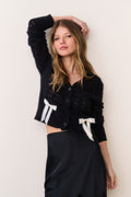 Midnight black cropped bow cardigan with V-neck, button front, and white bow patches