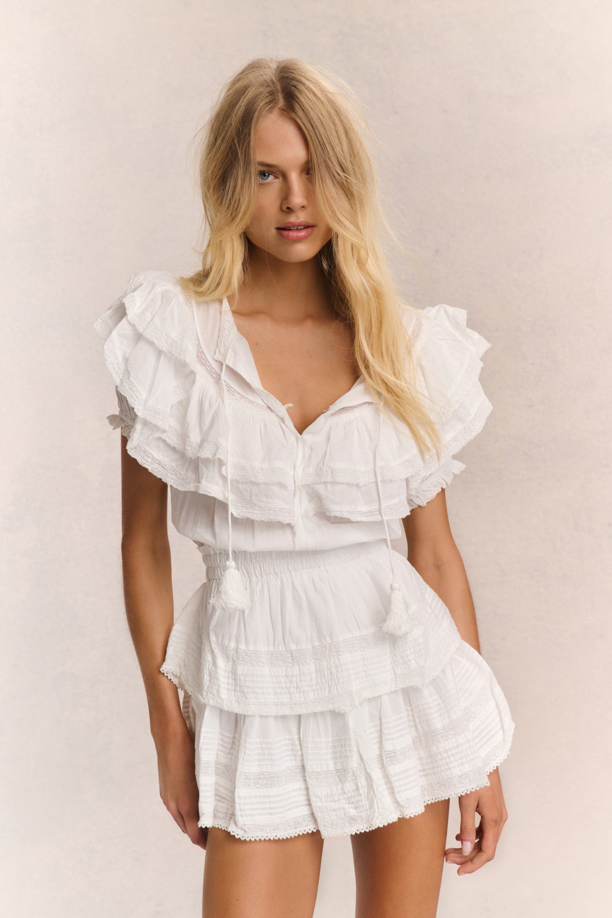 Antique white ruffled cotton mini dress with V-neck and tiered layers, short sleeves