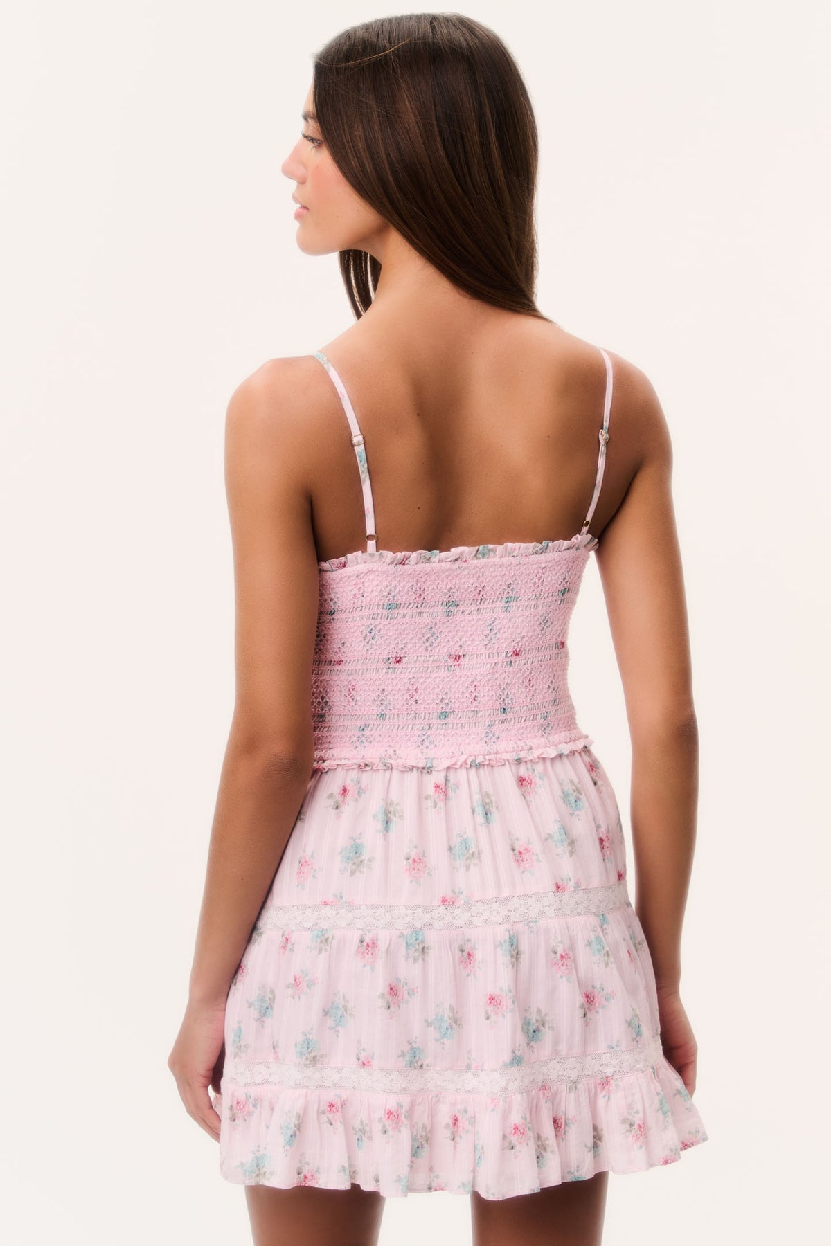 Back view of pink floral cotton mini dress with spaghetti straps and tiered skirt