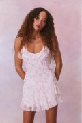 Silk mini dress with spaghetti straps, pink floral print, and ruffled tiered skirt.