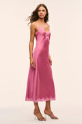 Pink lace bow maxi dress on model with V-neck, thin straps, and lace hem