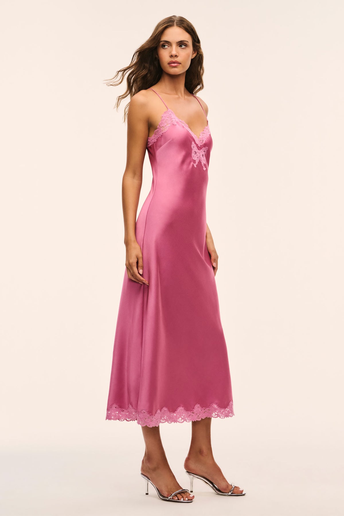 Pink lace bow maxi dress on model with V-neck, thin straps, and lace hem