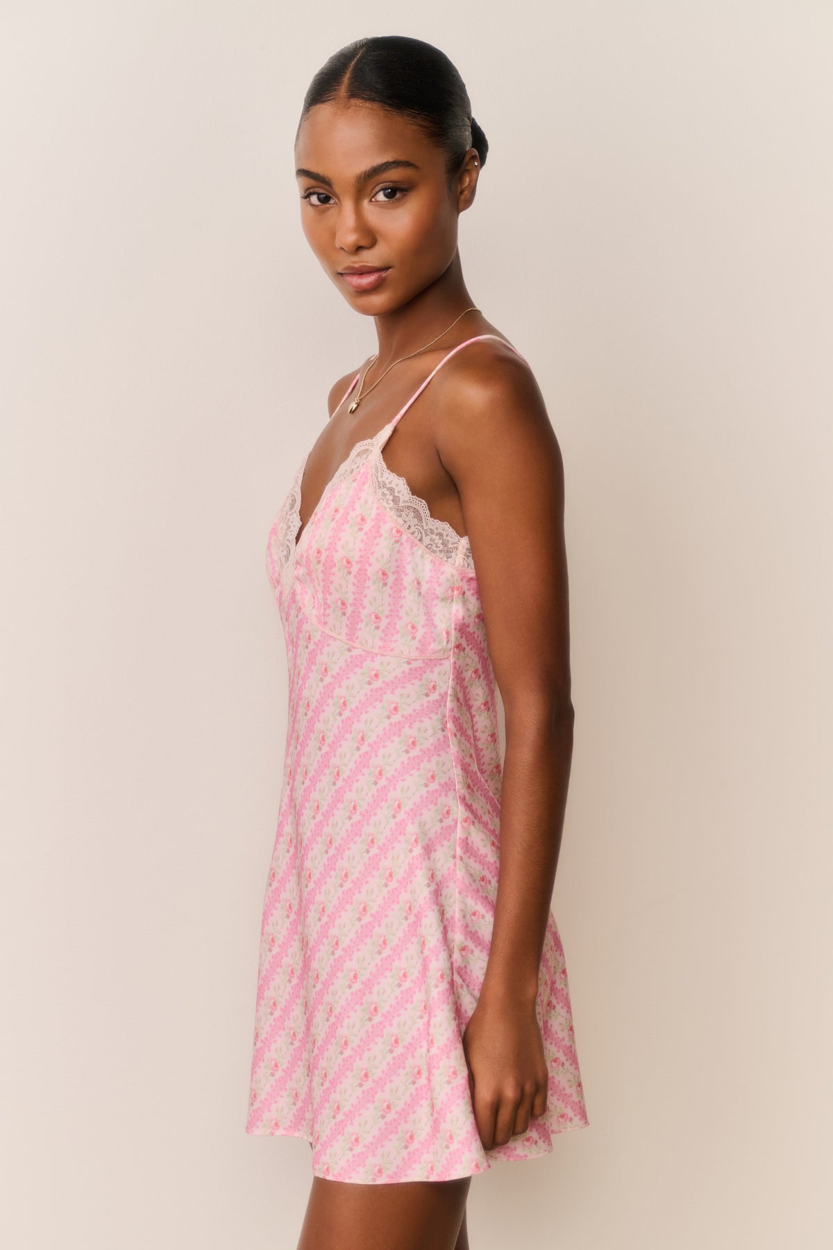Pink floral print mini slip dress with thin straps, lace V bust, and draped skirt