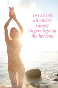 Sparkly pink floral dress worn by a woman standing on a beach at sunset
