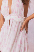 Close-up of white floral halter maxi dress bodice with elastic ruched waist