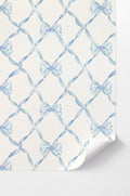 Peel-and-stick wallpaper with light blue bow pattern on white background