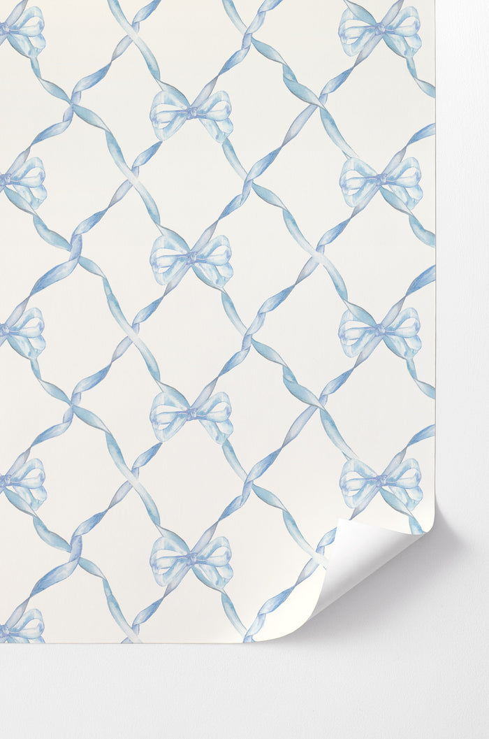 Peel-and-stick wallpaper with light blue bow pattern on white background