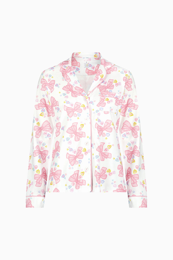 Women's long-sleeve pajama top in pink-and-white bow print with button front