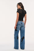 Bambie lace appliqué jeans, back view with wide-leg blue denim and black lace patches