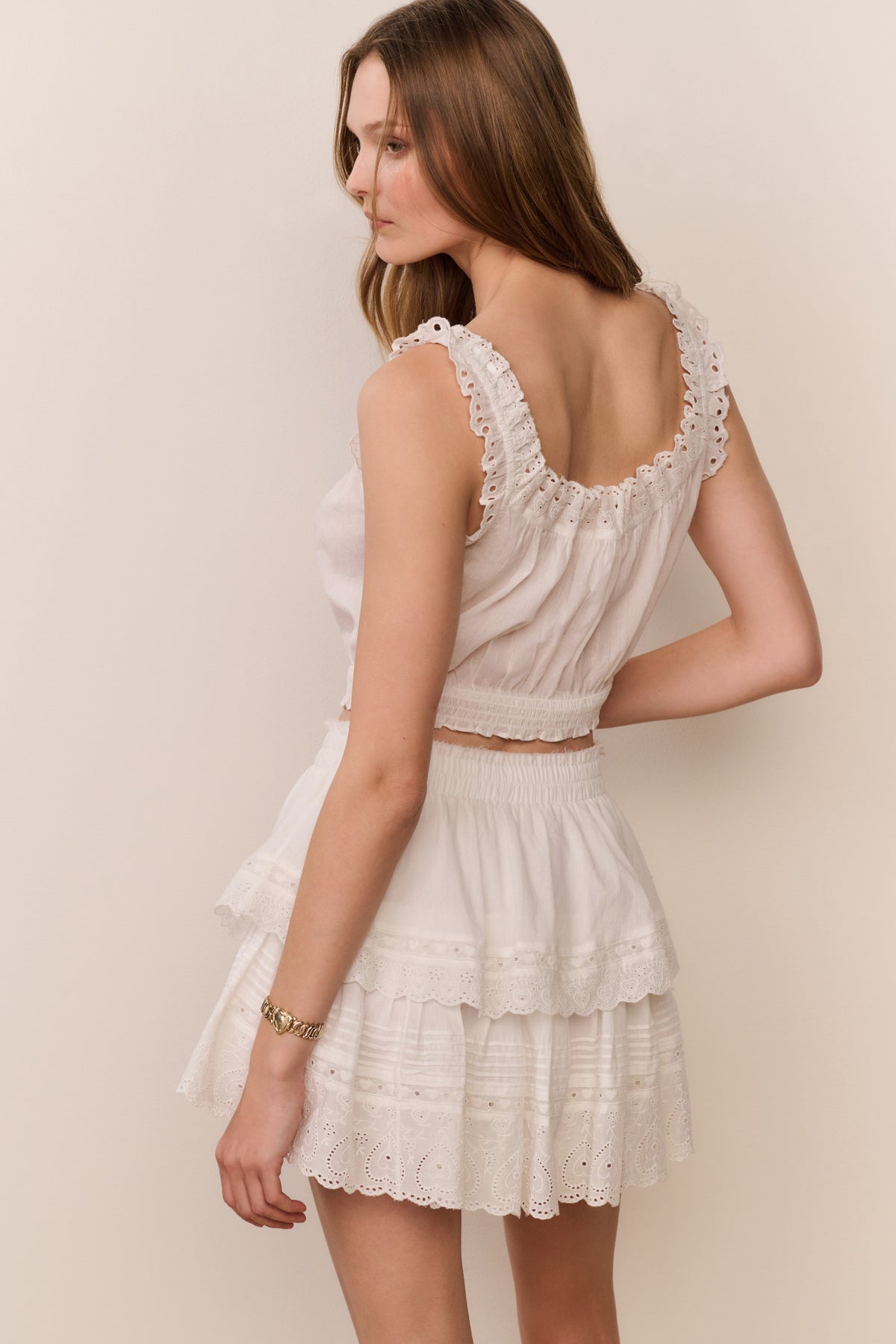White mini ruffle skirt with tiered eyelet detail and lace trim