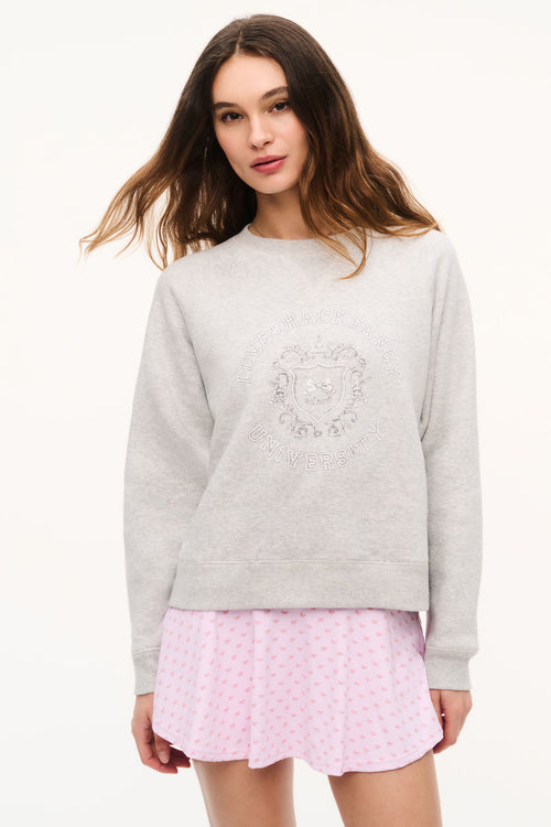 Light heather gray crewneck sweatshirt with centered crest graphic