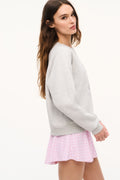Light heather gray sweatshirt with crewneck and crest graphic, side view