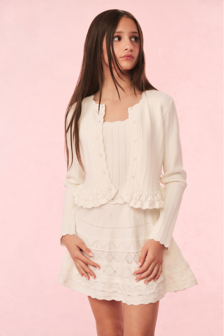 Ivory knit peplum cardigan with scalloped hem and button front